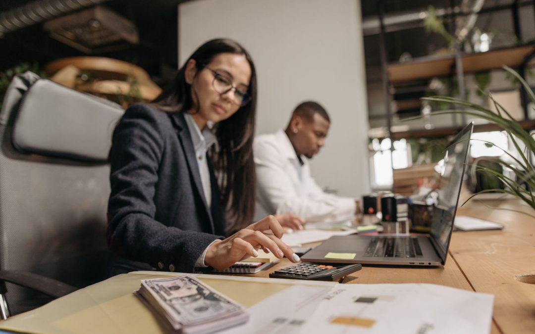 Accounting professional reviewing financials with a calculator at the office