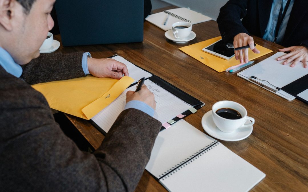 Executives exchanging confidential documents across a meeting table
